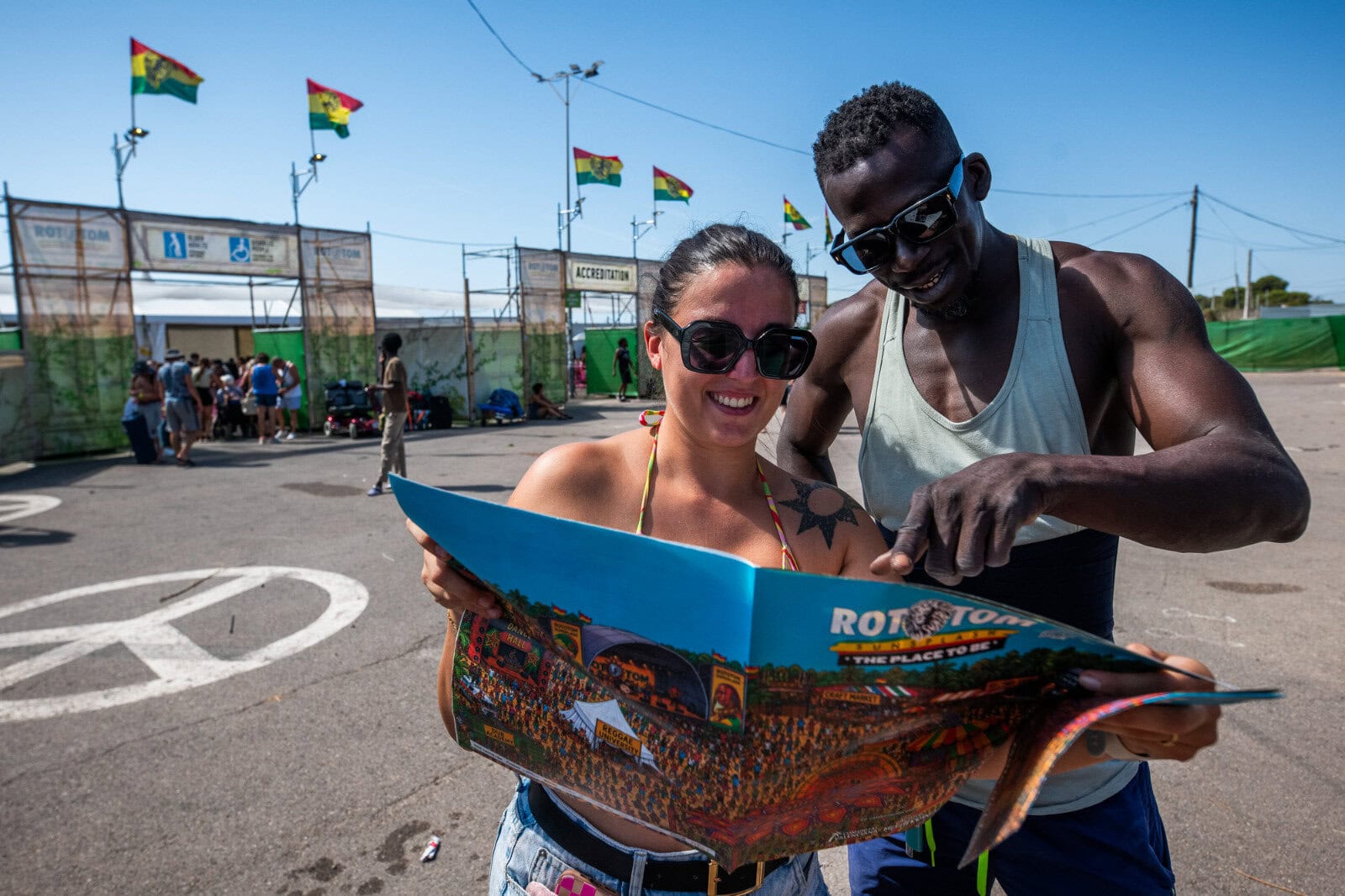 Visitors at Rototom Sunsplash reading a festival brochure.